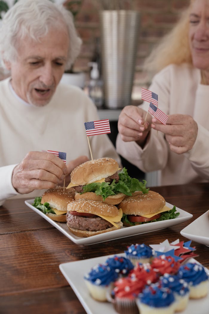 services-02 Senior adults enjoying American themed burgers with flags, perfect for a patriotic celebration.